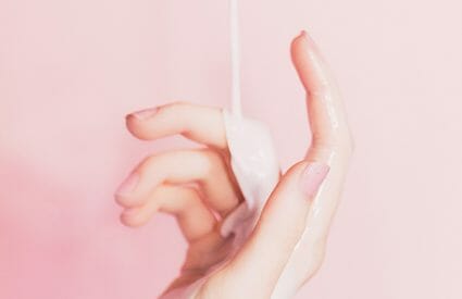woman's hand with lotion dripping on it