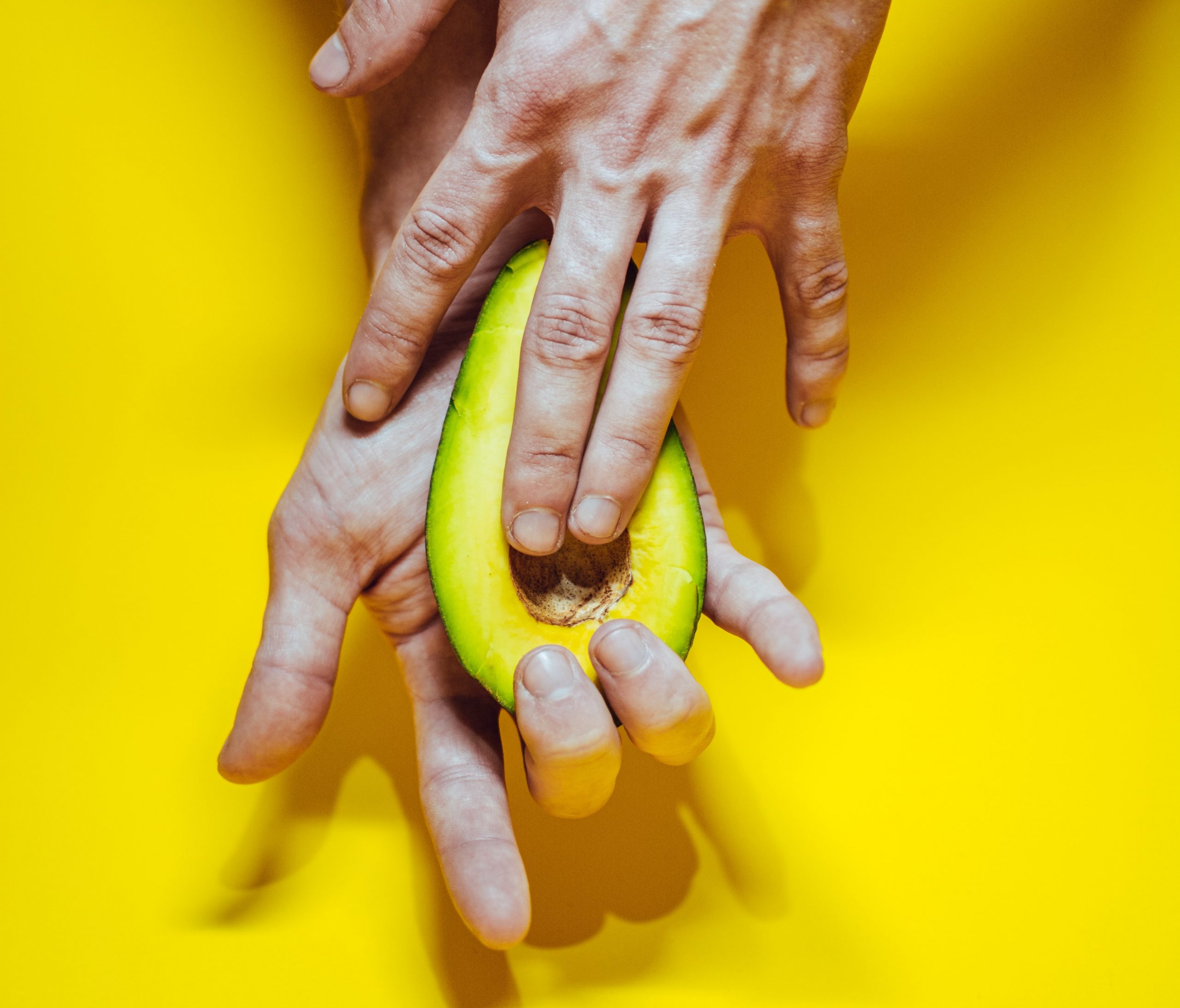 hands touching an avocado