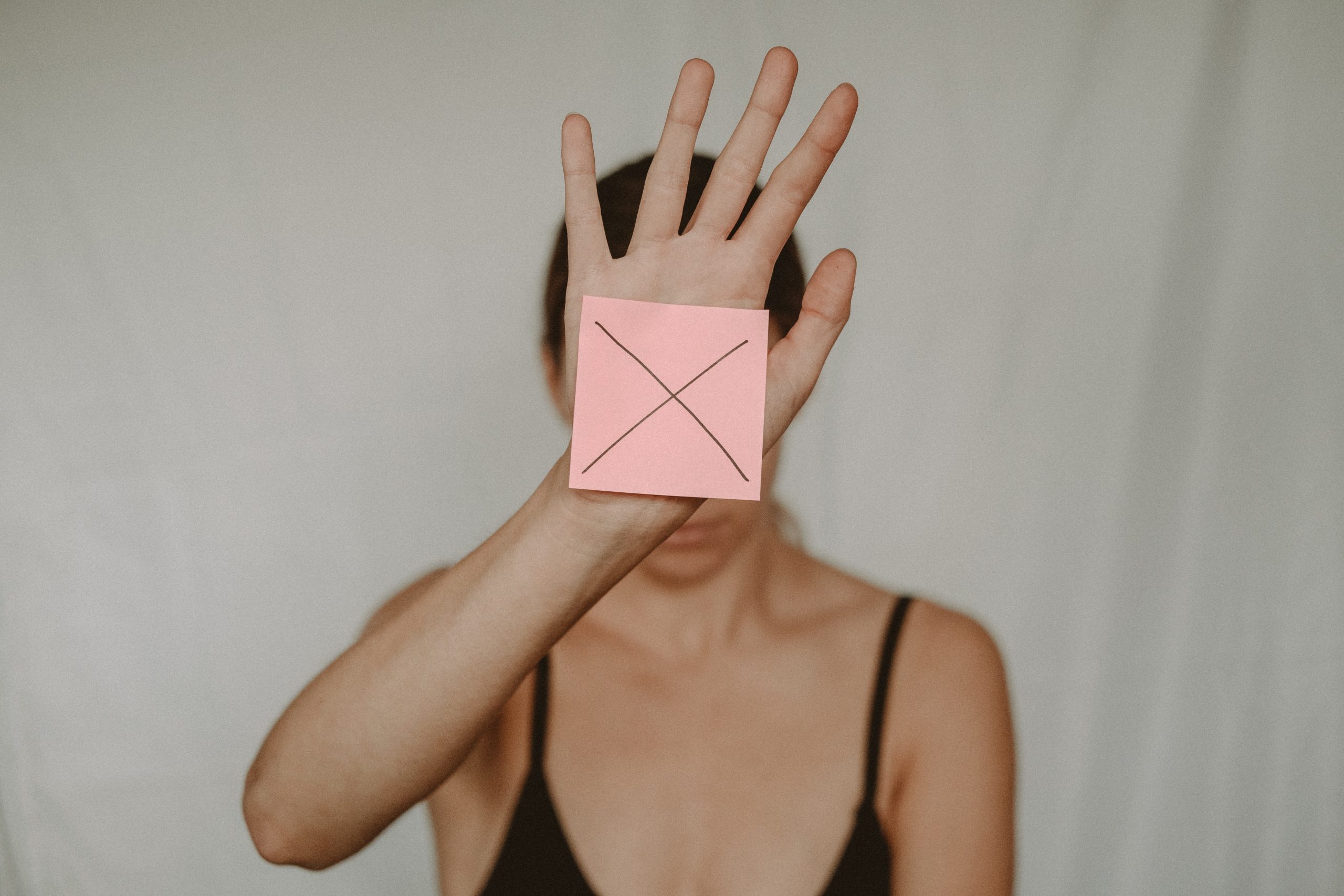 a woman with a X on a sticky note on her hand