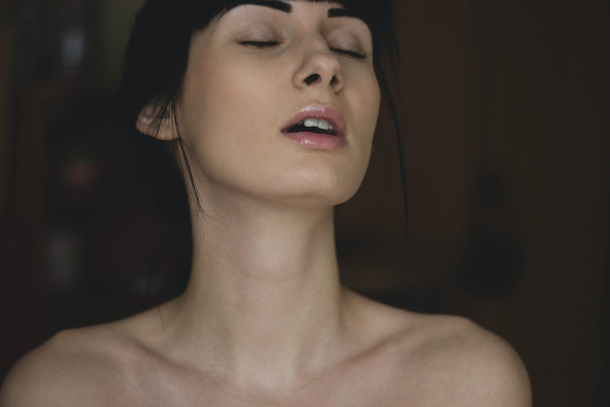 woman with her eyes closed experiencing pleasure