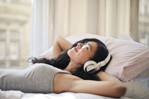 a woman wearing headphones in bed