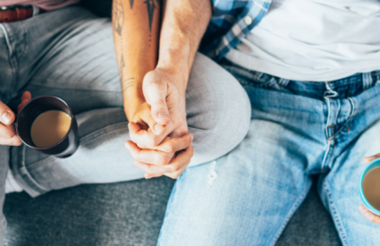 a couple holding hand and drinking coffee