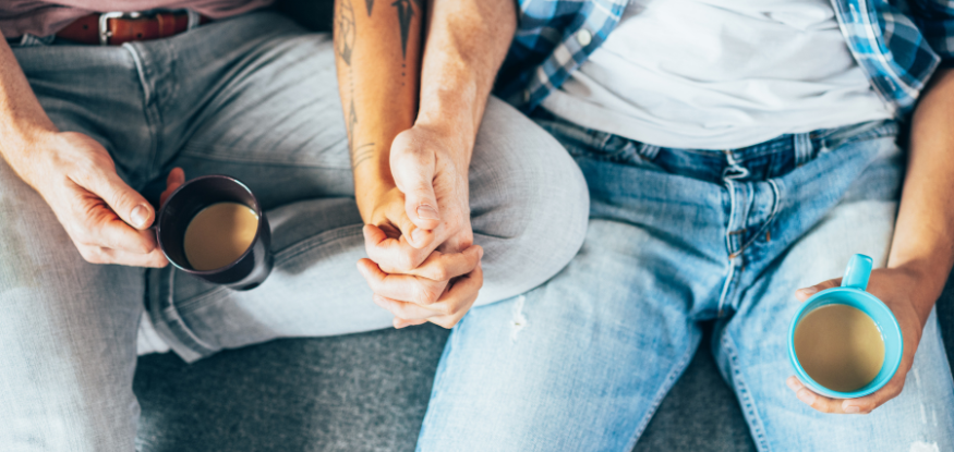 a couple holding hand and drinking coffee